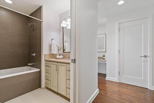 bathroom with vanity, wood-type flooring, and tiled shower / bath