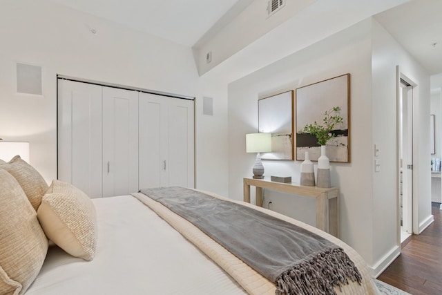 bedroom with dark hardwood / wood-style floors and a closet