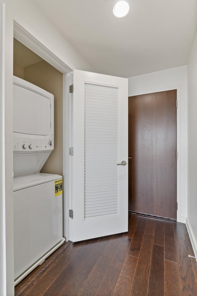 washroom with stacked washer / dryer and dark wood-type flooring