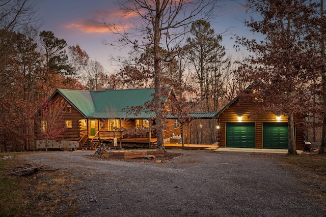 log home featuring a porch and a garage