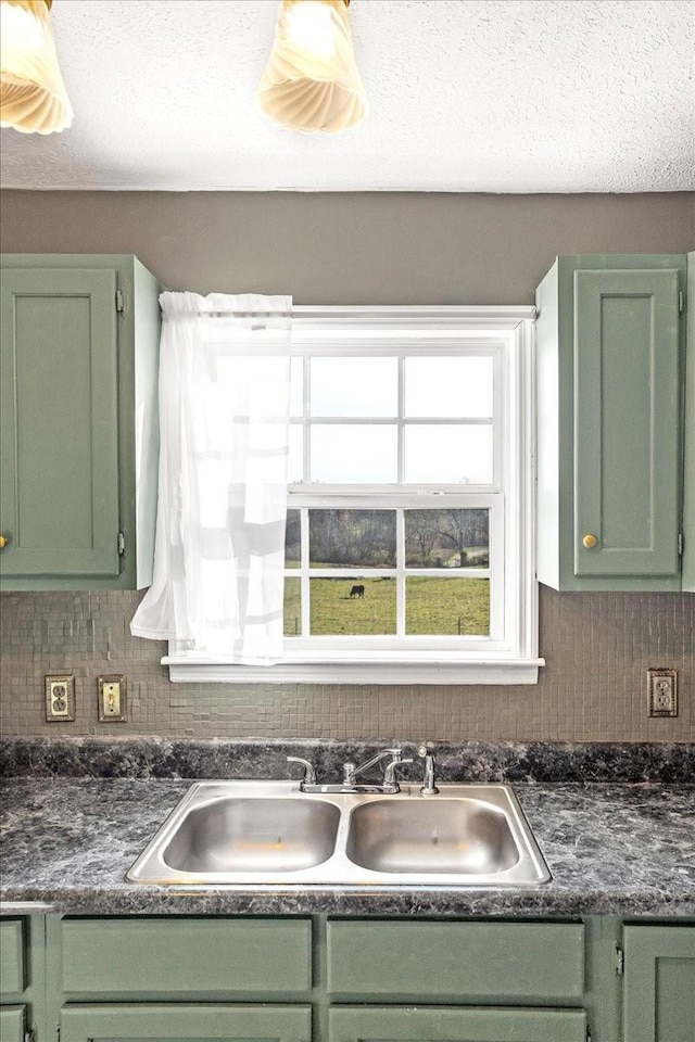 kitchen featuring tasteful backsplash, green cabinets, and sink