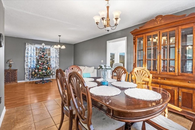 dining space featuring a notable chandelier, a textured ceiling, and light hardwood / wood-style flooring