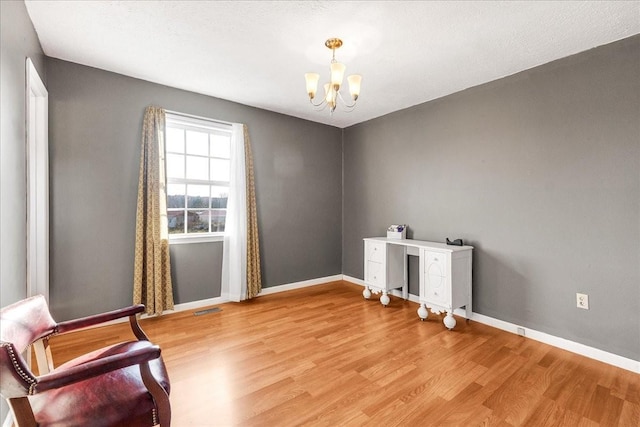 unfurnished room with light hardwood / wood-style floors and an inviting chandelier