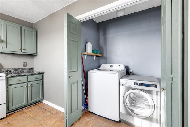 laundry area with washing machine and dryer, light tile patterned floors, and a textured ceiling