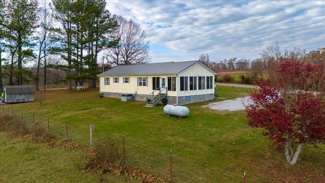 back of property featuring a yard and a sunroom