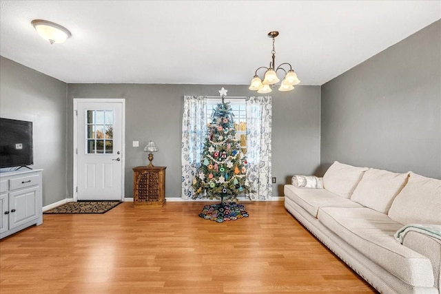 living room with light wood-type flooring and an inviting chandelier