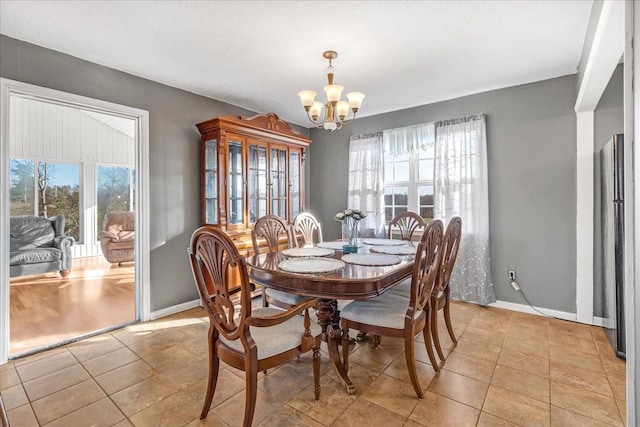 dining space with light tile patterned floors and a notable chandelier