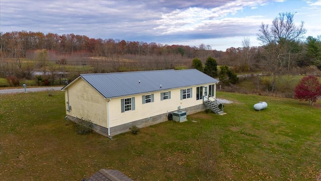 back of property featuring a yard and central AC unit