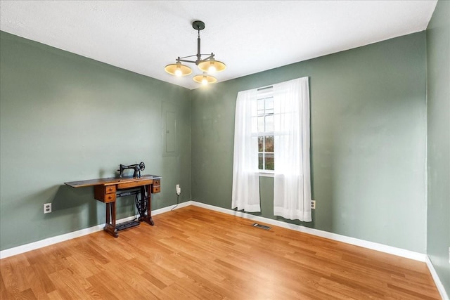 spare room featuring hardwood / wood-style floors and an inviting chandelier