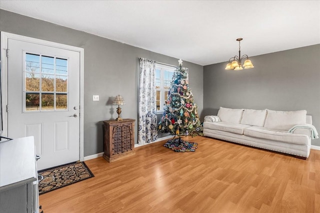 living room featuring a chandelier, a healthy amount of sunlight, and light hardwood / wood-style floors