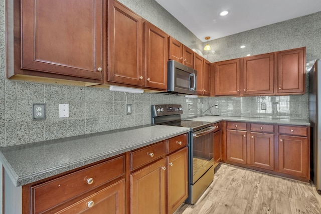 kitchen with decorative backsplash, stainless steel appliances, and light hardwood / wood-style flooring