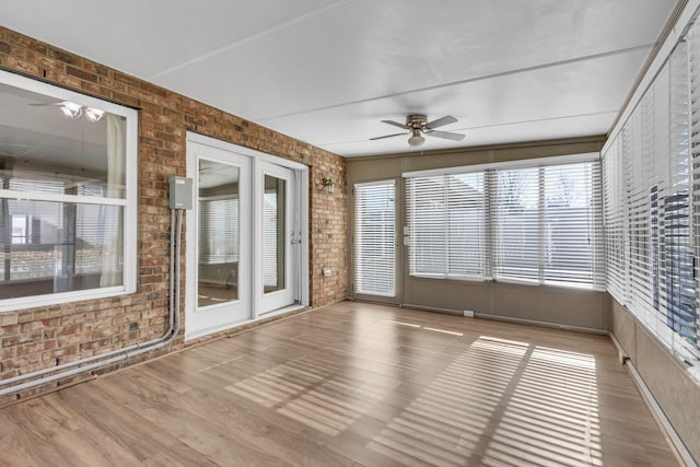 unfurnished sunroom featuring ceiling fan