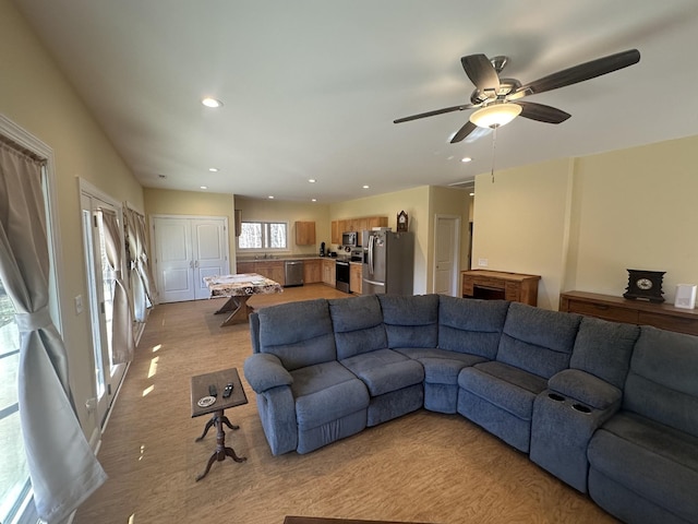 carpeted living room featuring ceiling fan