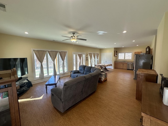 living room featuring hardwood / wood-style floors and ceiling fan