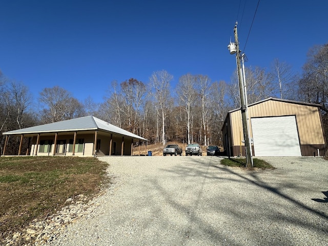 view of side of property featuring covered porch, an outbuilding, and a garage