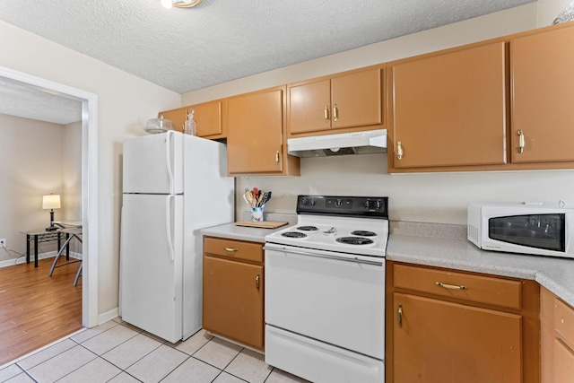 kitchen featuring a textured ceiling, white appliances, and light hardwood / wood-style flooring