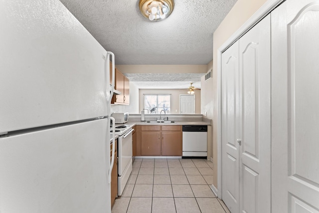 kitchen with white appliances, a textured ceiling, ceiling fan, sink, and light tile patterned floors