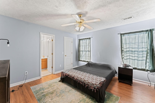 bedroom with hardwood / wood-style flooring, ceiling fan, and a textured ceiling