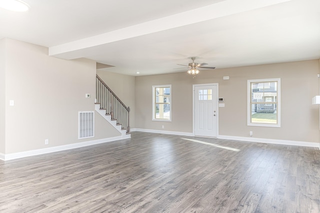 foyer entrance with visible vents, wood finished floors, stairway, baseboards, and ceiling fan