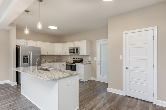 kitchen featuring a kitchen island with sink, a sink, dark wood-style floors, stainless steel appliances, and white cabinets