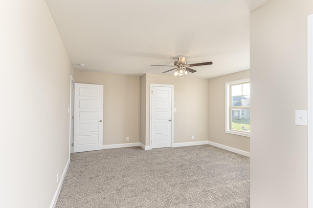 spare room with baseboards, carpet, and a ceiling fan