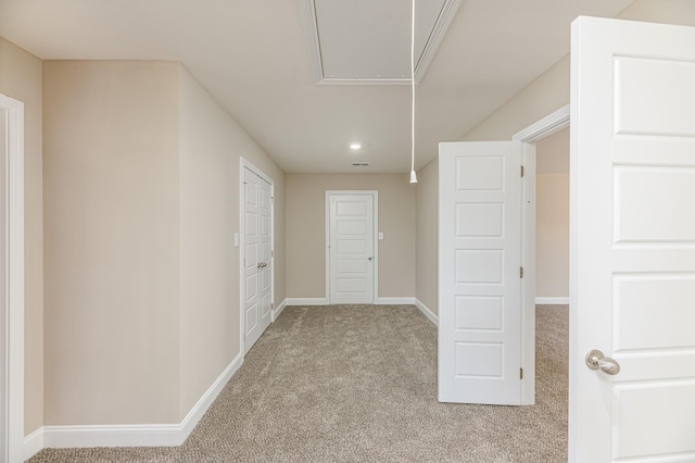 interior space with visible vents, baseboards, attic access, and carpet flooring