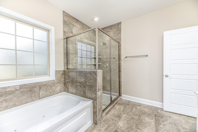 bathroom featuring a stall shower, baseboards, and a whirlpool tub