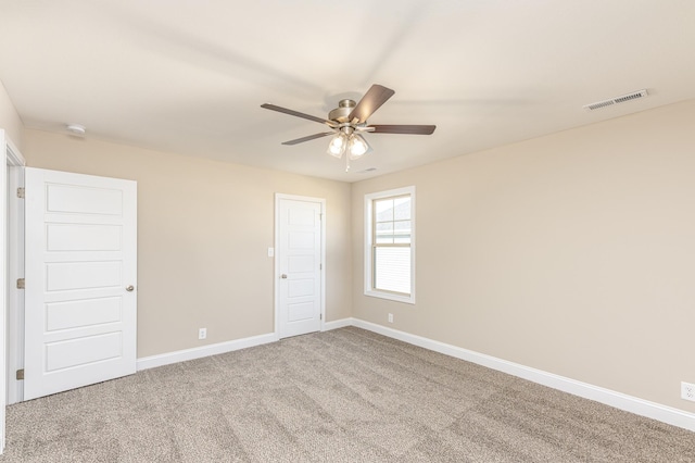 spare room with visible vents, a ceiling fan, baseboards, and carpet floors