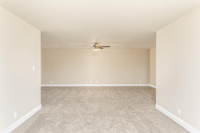 unfurnished room with a ceiling fan, baseboards, and light carpet