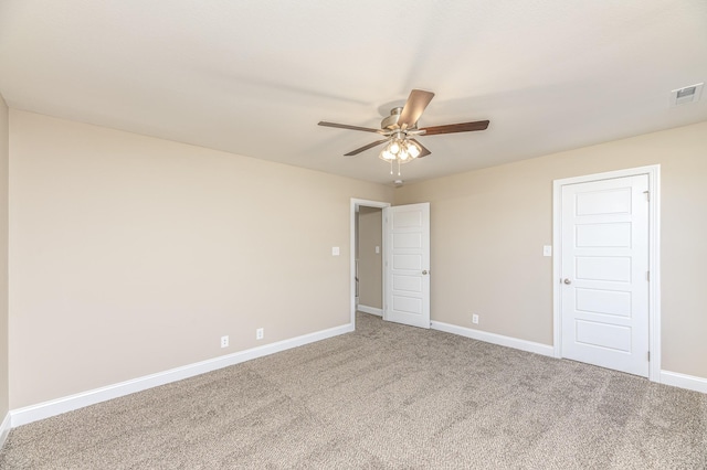 unfurnished room featuring visible vents, carpet flooring, a ceiling fan, and baseboards