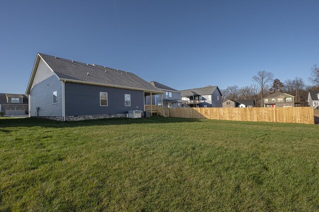 rear view of house with a yard, fence, a residential view, and cooling unit