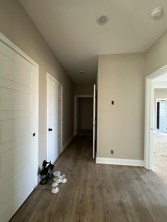 hallway with baseboards and dark wood-style flooring