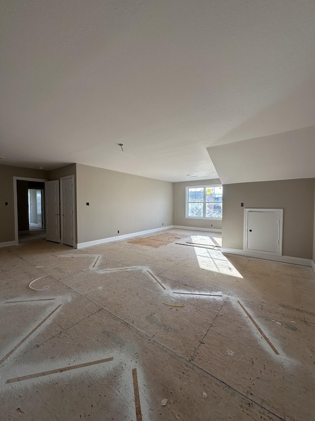 interior space featuring baseboards and vaulted ceiling