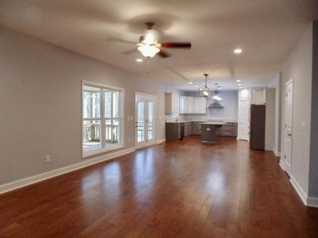 unfurnished living room with french doors, dark hardwood / wood-style floors, and ceiling fan