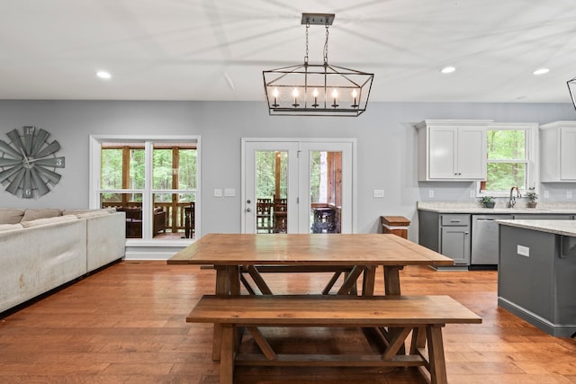 dining room featuring plenty of natural light, sink, and light hardwood / wood-style flooring