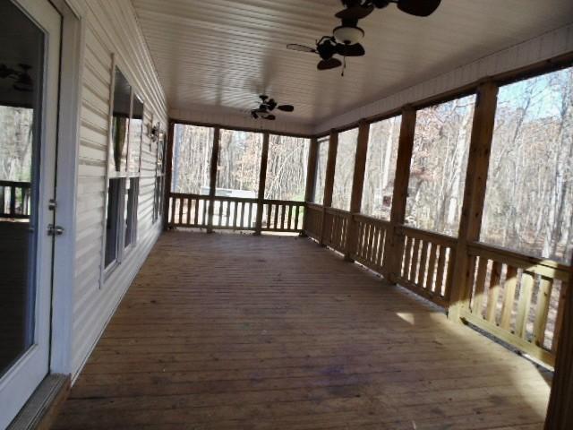 unfurnished sunroom featuring plenty of natural light and ceiling fan