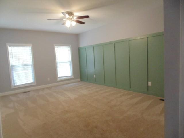 empty room with ceiling fan and light carpet