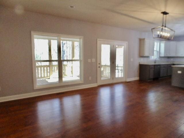 interior space featuring a chandelier, french doors, and dark hardwood / wood-style flooring