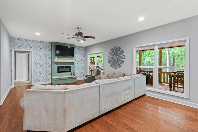 living room featuring a fireplace, hardwood / wood-style flooring, plenty of natural light, and ceiling fan