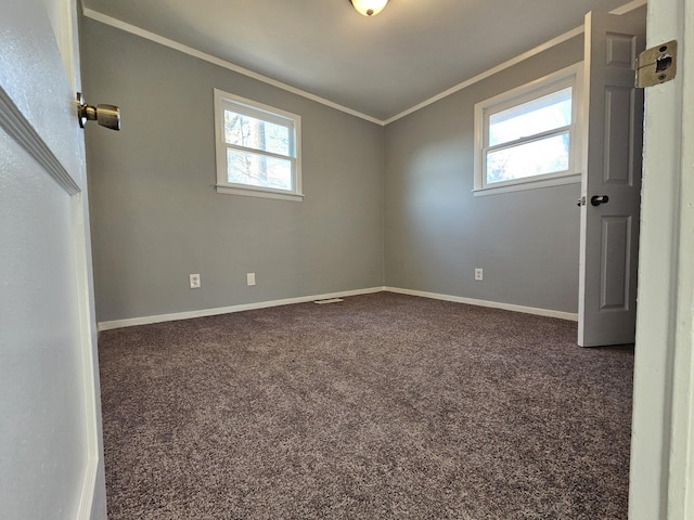 empty room featuring dark carpet and ornamental molding