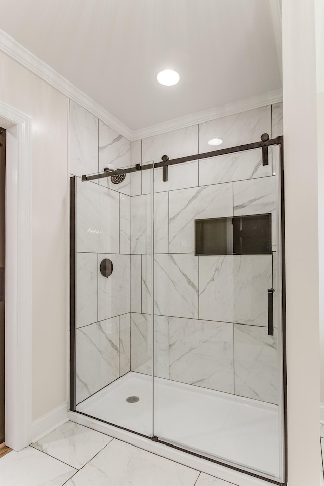 bathroom with a shower with shower door and ornamental molding