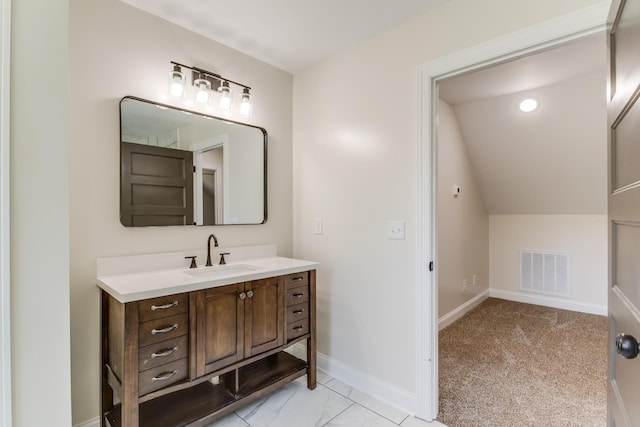 bathroom featuring vanity and lofted ceiling