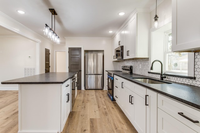 kitchen with white cabinets, decorative light fixtures, stainless steel appliances, and sink