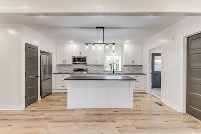 kitchen featuring light hardwood / wood-style flooring, white cabinets, hanging light fixtures, and appliances with stainless steel finishes