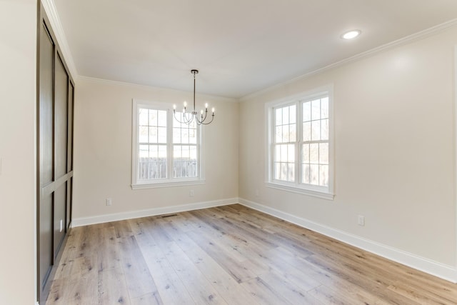 unfurnished dining area featuring a notable chandelier, light wood-type flooring, and ornamental molding