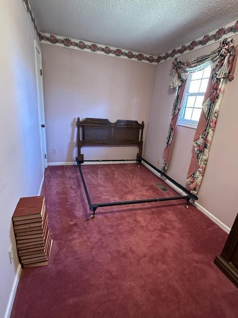 unfurnished bedroom featuring carpet floors and a textured ceiling