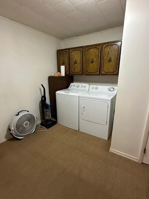 laundry room with washing machine and clothes dryer, carpet floors, and cabinets