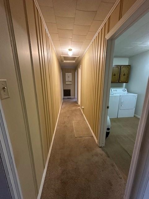 hall with light carpet, crown molding, and independent washer and dryer