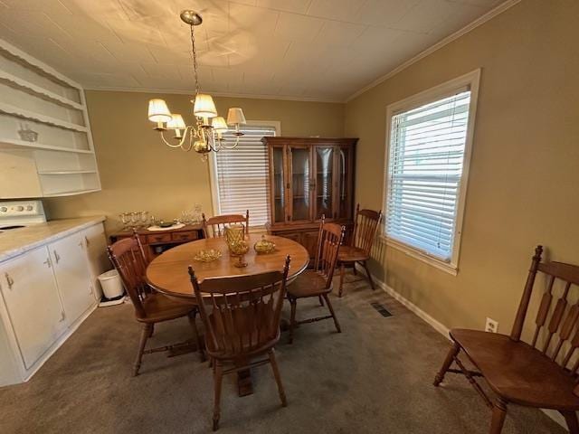 carpeted dining room featuring a chandelier and ornamental molding