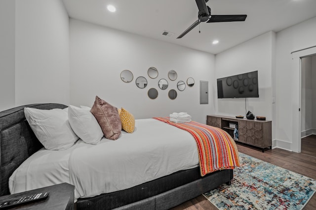 bedroom featuring dark hardwood / wood-style flooring, electric panel, and ceiling fan